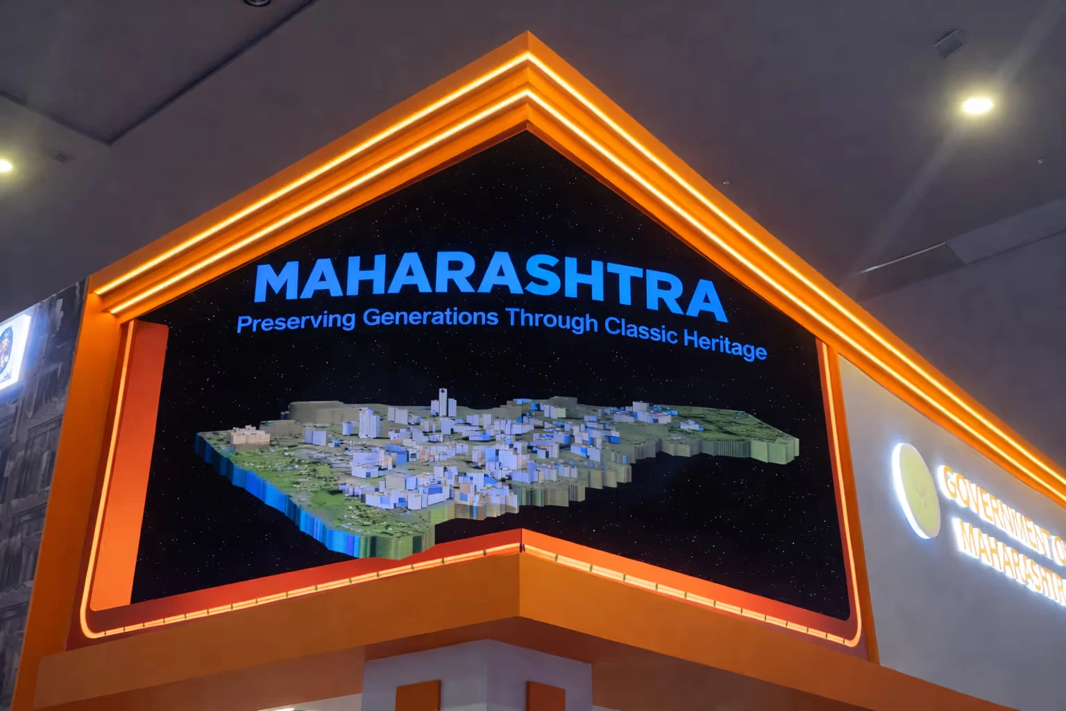 3D model map of Maharashtra state with the text 'MAHARASHTRA Preserving Generations Through Classic Heritage' displayed on a large screen inside an orange-framed booth.