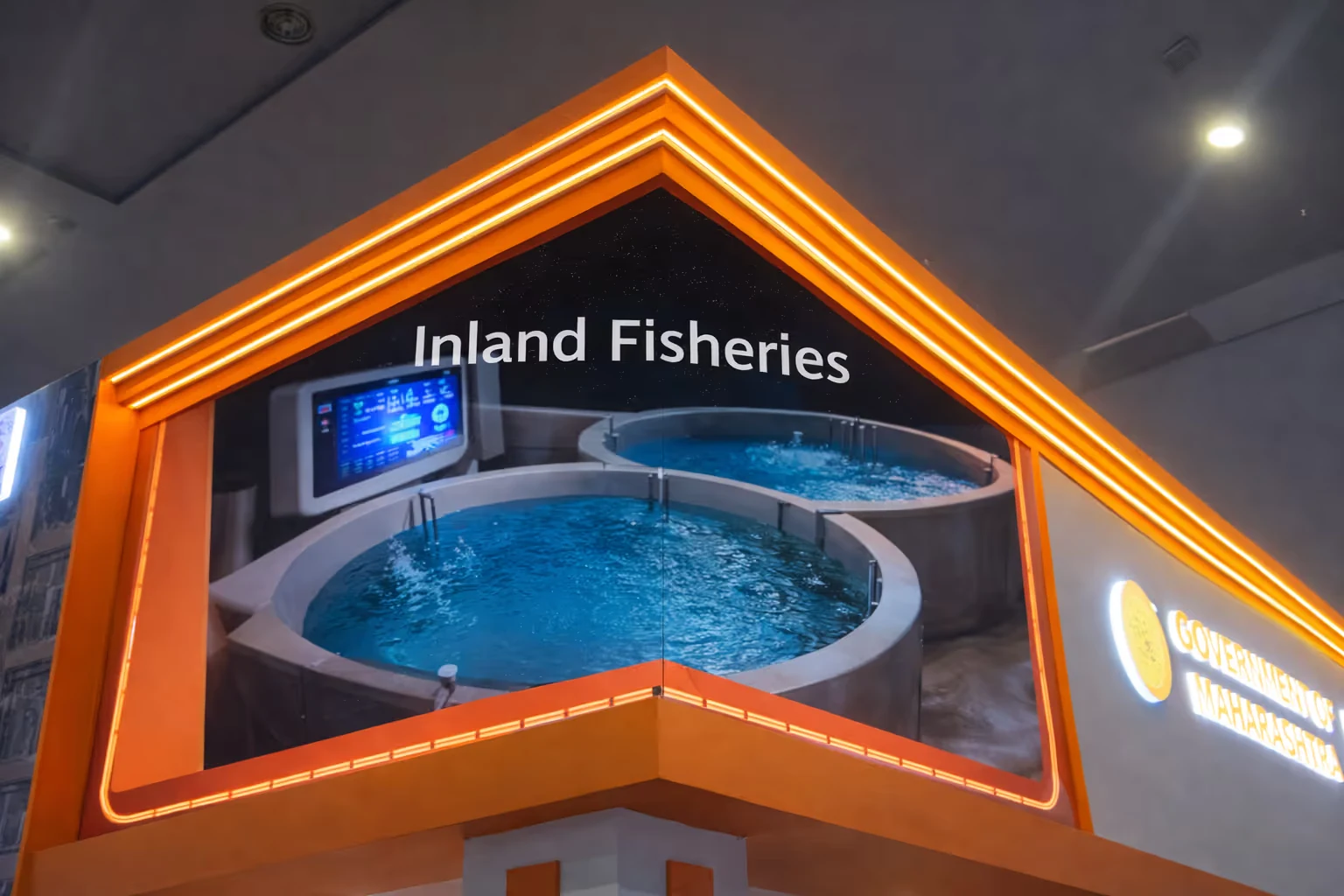 Exhibit display with large images of circular fish tanks labeled Inland Fisheries, featuring a digital monitoring screen inside an orange-framed structure.