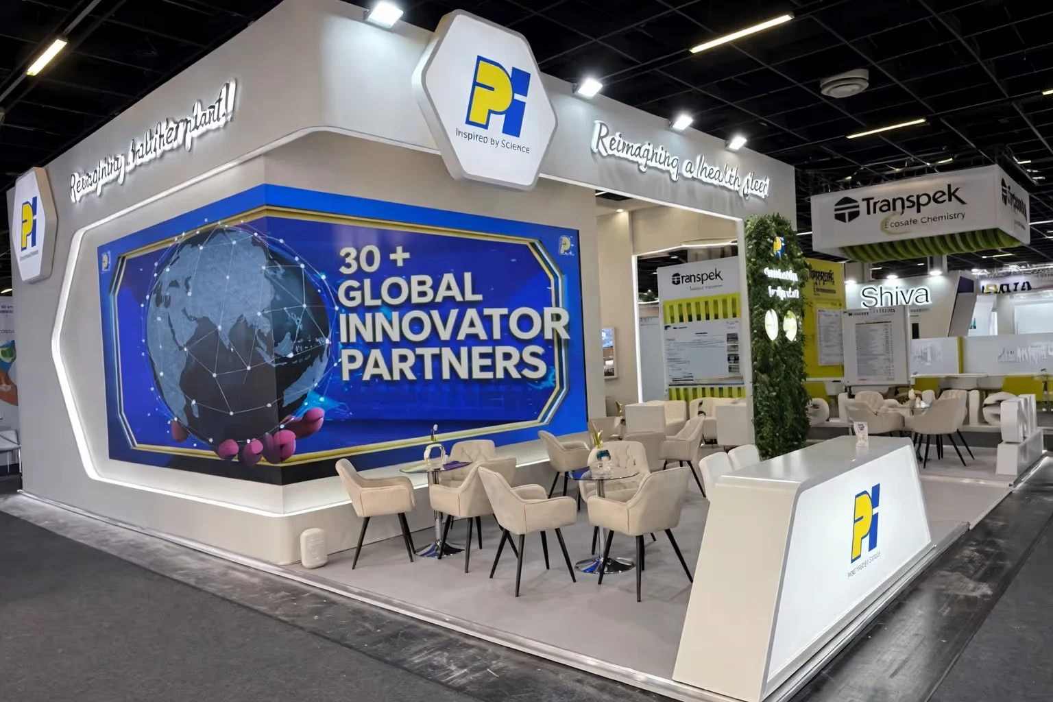 Exhibition booth with large screen displaying 30+ Global Innovator Partners and seating area with beige chairs and tables.