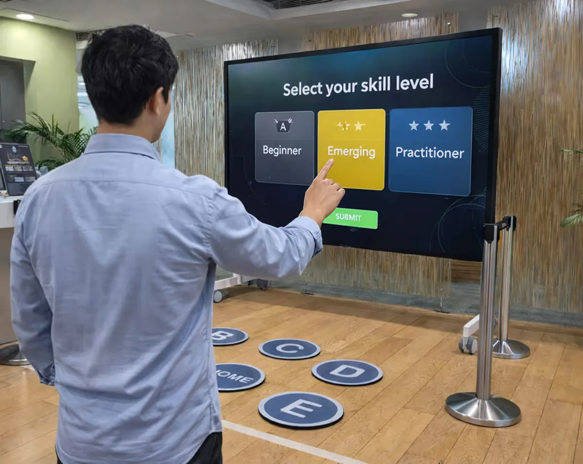 Man selecting 'Emerging' skill level on a large touchscreen in an indoor setting.